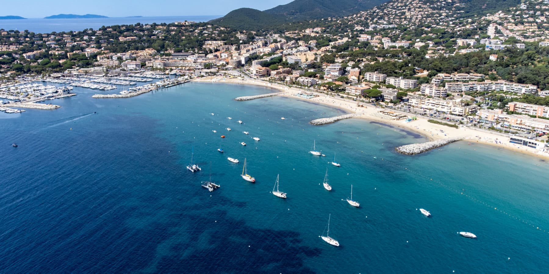 Aerial view on boats, crystal clear blue water of Plage du Debarquement white sandy beach near Cavalaire sur Mer and La Croix Valmer, summer vacation on French Riviera, Var, France